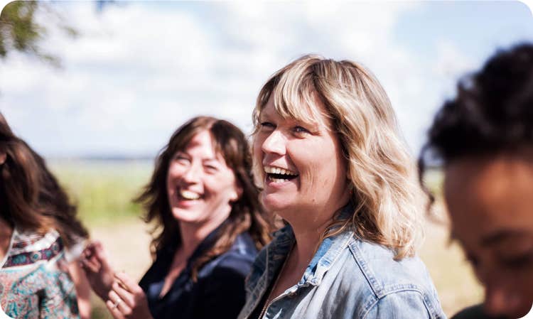 several women looking forward and smiling together