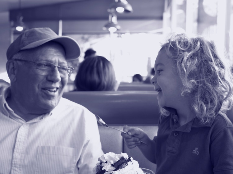 Older and younger family members smiling in a diner