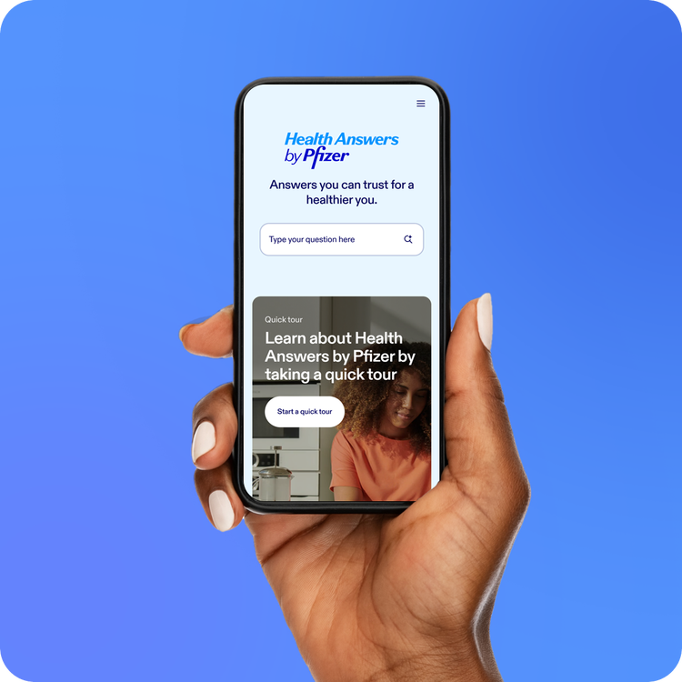 Hand holding a smartphone displaying Health Answers by Pfizer on the screen