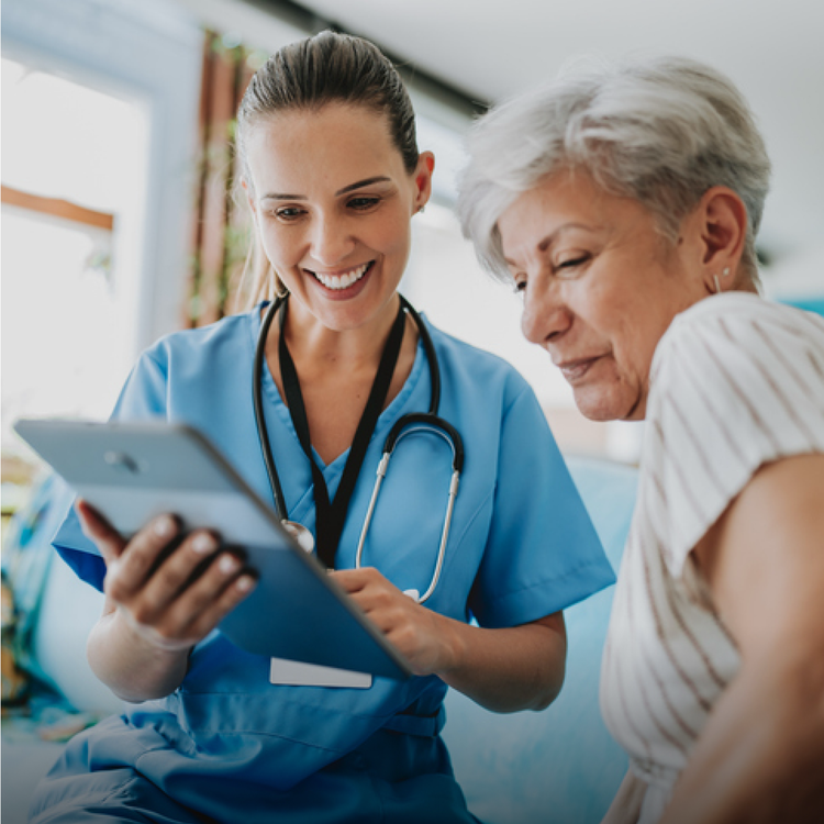 A healthcare worker showing a woman a tablet