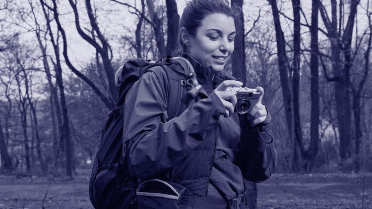 Woman photographer taking photos in the woods