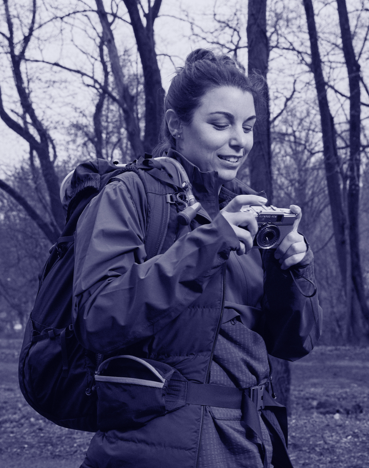 Woman photographer taking photos in the woods