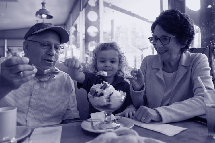 Older man and woman eating ice cream with a little girl in a diner